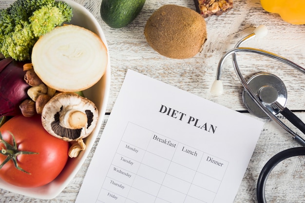 Foto gratuita dieta piano con verdure e stetoscopio sullo scrittorio di legno