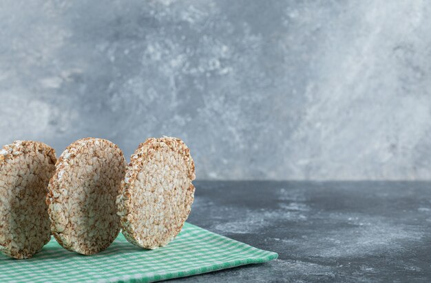 Dietary round rice cakes on striped tablecloth.