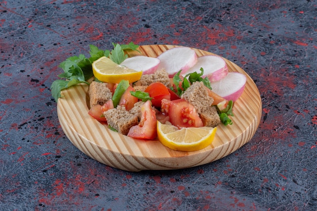 Free photo dietary salad mix and sliced turnips served on a wooden platter on dark colored background. high quality photo