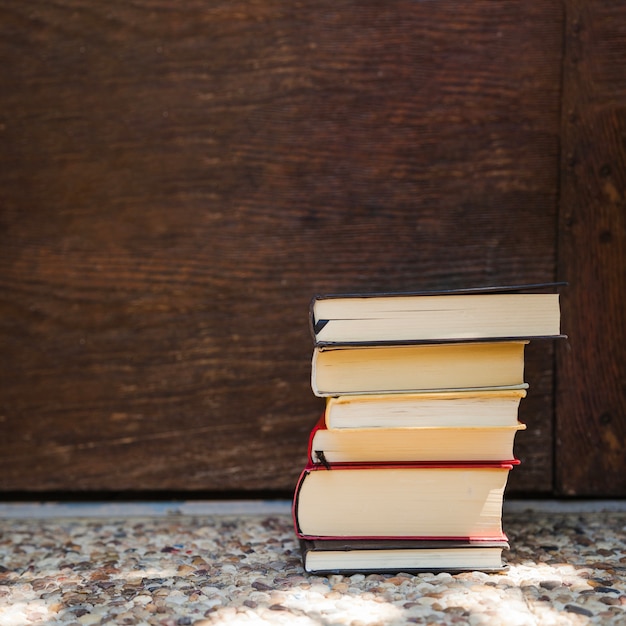 Different books stacked on ground