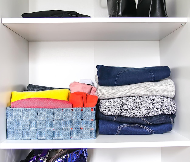 Разная одежда в домашнем гардеробе. небольшая организация пространства. вертикальное хранилище.