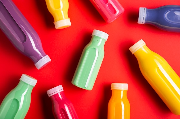 Different colored smoothies on red background
