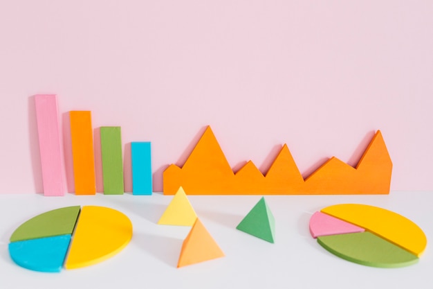 Different colorful graph with pyramid shapes against pink background