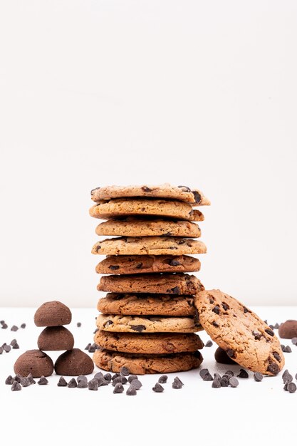 Different cookies with chocolate pieces on white surface