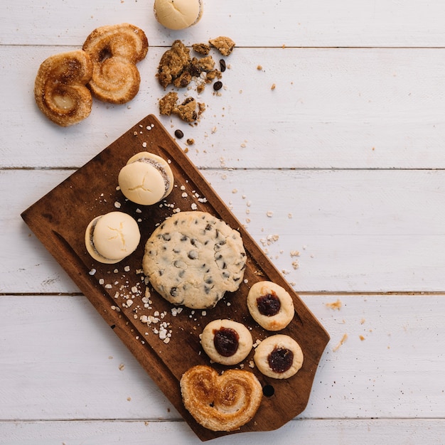 Different cookies on wooden board 