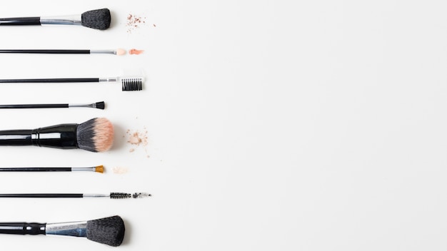 Different cosmetic brushes arranged on white background