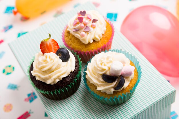 Different cupcakes with berries on box