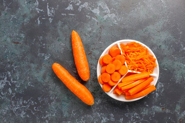 Different cuts of carrot in bowls.