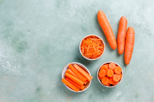 Different cuts of carrot in bowls.