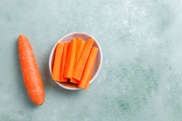 Free photo different cuts of carrot in bowls.