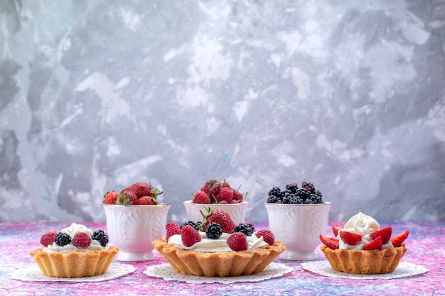 разные вкусные торты со сливками и свежими ягодами на светлом столе, ягодно-фруктовый бисквит