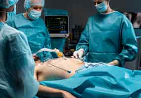 Foto gratuita diversi medici che eseguono una procedura chirurgica