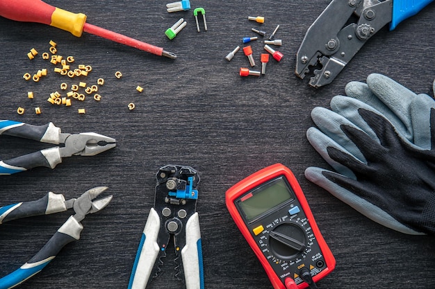 Different electrical tools on wooden background flat lay