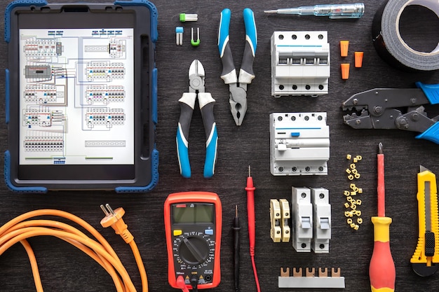 Different electrical tools on wooden background flat lay