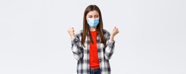 Different emotions covid19 pandemic coronavirus selfquarantine and social distancing concept Satisfied happy young woman in medical mask fist pump in celebration victory success achieved