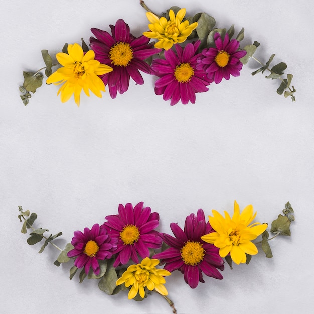 Different flowers with green branches on table