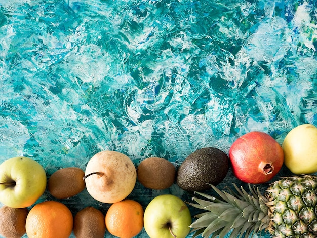 Free photo different fresh fruits on colorful wooden background