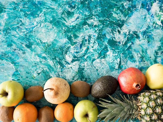 Different fresh fruits on colorful wooden background