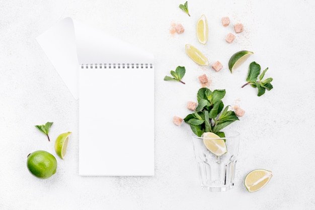 Different ingredients on white background with empty notepad