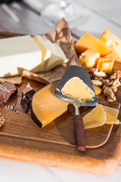 The different kind of cheese and walnuts on wooden background