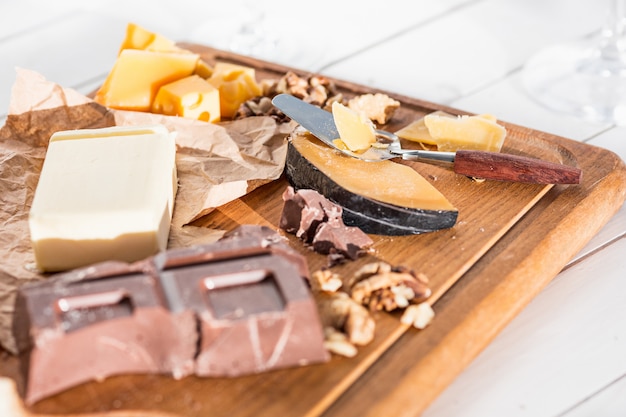 different kind of cheese and walnuts on wooden