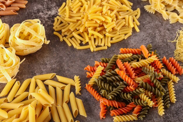 different kind of raw pasta isolated on the gray surface