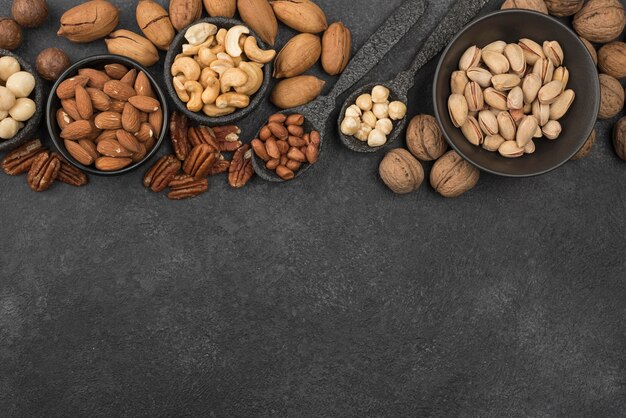 Different kinds of nuts on dark copy space background