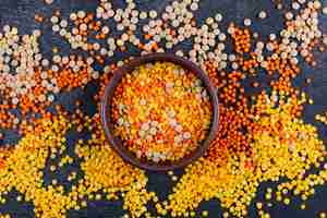 Free photo different lentils in a brown bowl top view on a black stone table