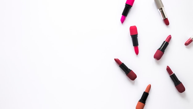 Different lipsticks scattered on table