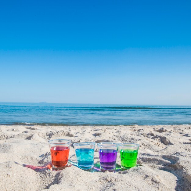 Different liquors in shots on beach