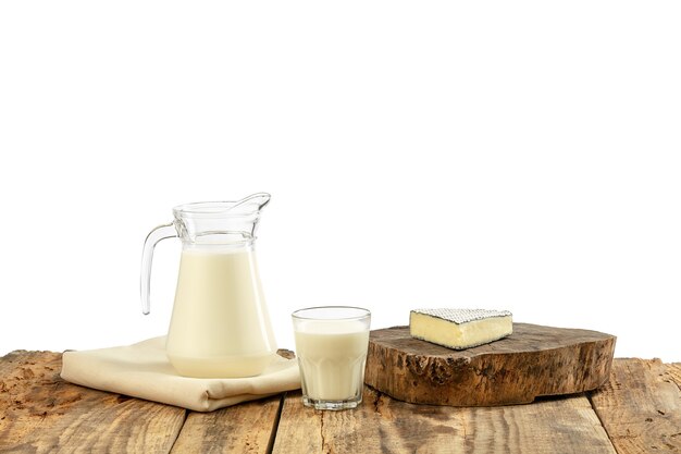 Different milk products, cheese, cream, milk on wooden table and white wall. Healthy eating and lifestyle, organic natural nutrition, diet. Delicious food and drinks.