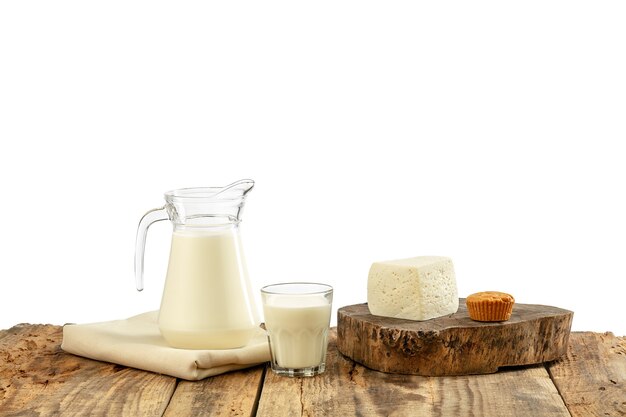 Different milk products, cheese, cream, milk on wooden table and white wall. Healthy eating and lifestyle, organic natural nutrition, diet. Delicious food and drinks.