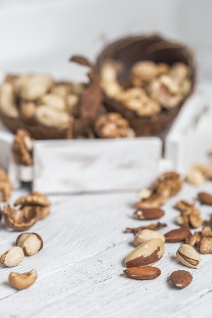 different nuts closeup on white wooden background