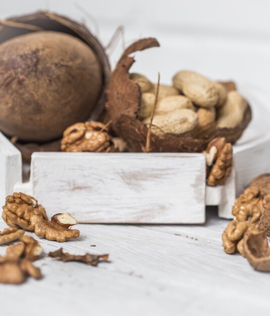 different nuts closeup on white wooden background