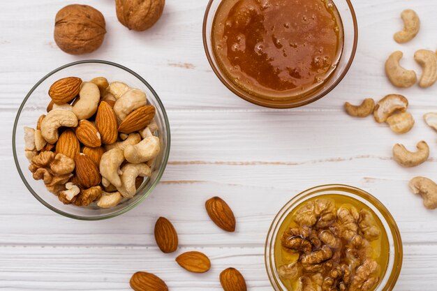 Different nuts with honey on table
