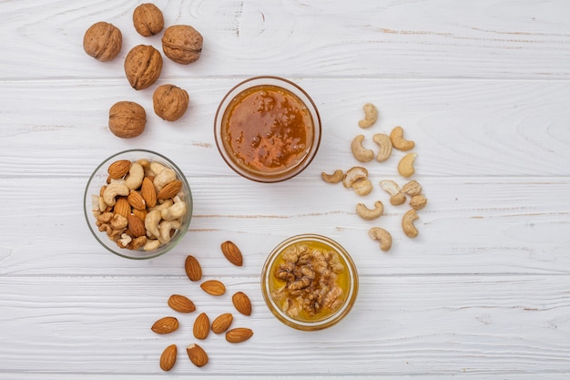 Different nuts with honey on white table