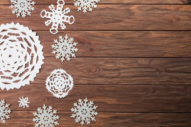 Different paper snowflakes on wooden board