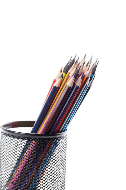 Different pencils colored graphite and drawing inside black basket on white wall