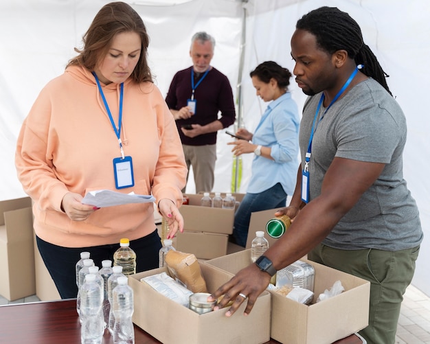 Foto gratuita diverse persone che fanno volontariato in un banco alimentare