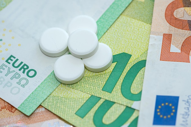 Different pills medications with european money as background Premium Photo