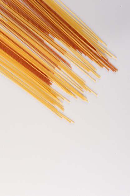 different raw spaghetti with copy space on white surface