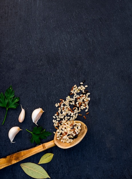 Different rice grains in wooden spoon 