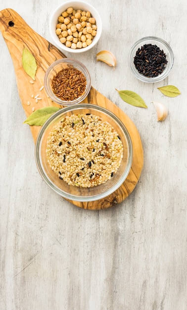 Different rice types in bowls on wooden board