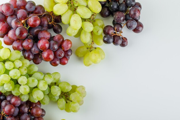Different ripe grapes flat lay on a white