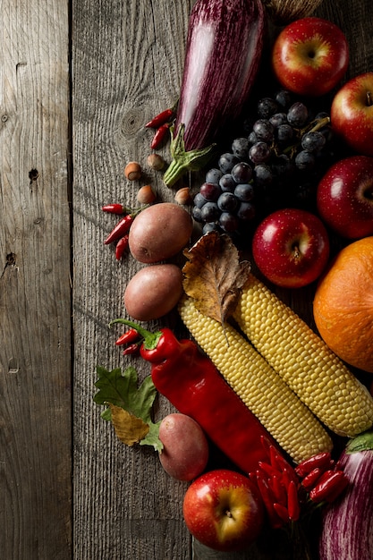 Different seasonal autumn vegetables and fruits on wooden background