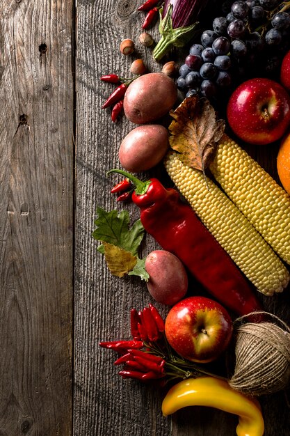 Different seasonal autumn vegetables and fruits on wooden background