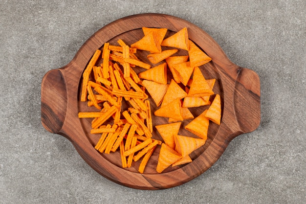 Different shape chips on wooden board over grey.