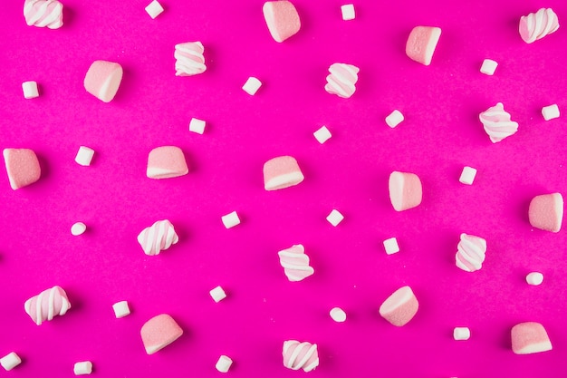 Different shape of marshmallows on pink background