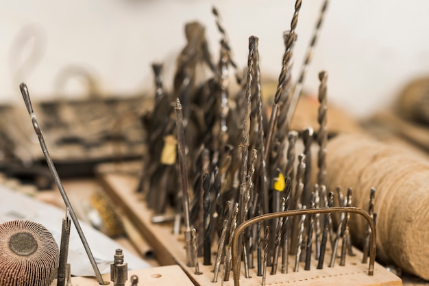 Different sizes drill bits on wooden board