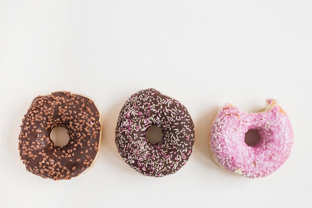 Free photo different type of baked donuts on white background